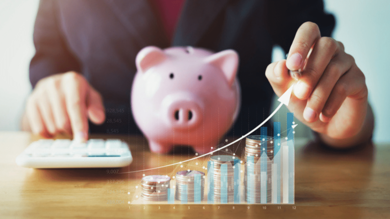 business woman holding pen pointing in graph with coins . concept saving money for future