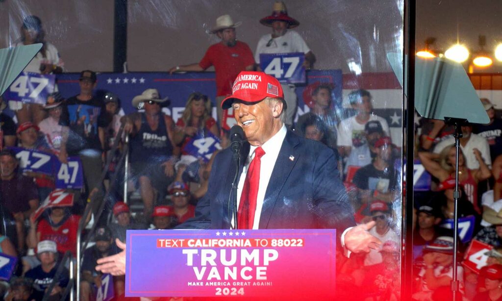 Trump smiling as he is speaking at the Trumchella Trump Coachella Rally